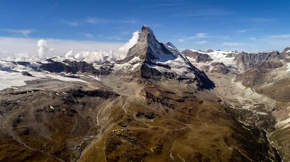 Cordilheira escarpada coberta de neve vista de cima, terreno de expedição em mundo aberto